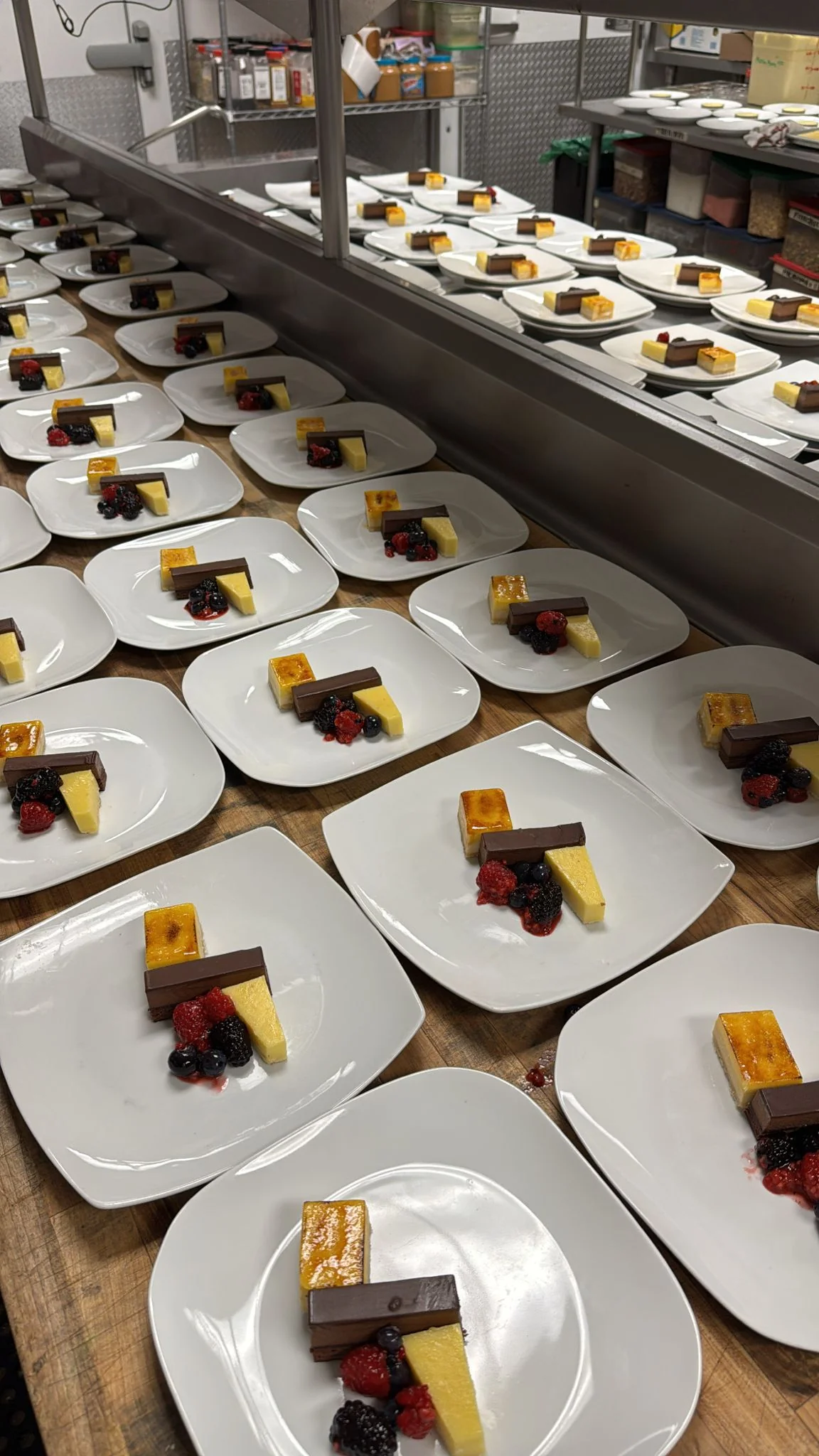 Brûlée & Ganache Bar — crème brûlée slice with dark chocolate ganache bar and mixed berry coulis for banquet